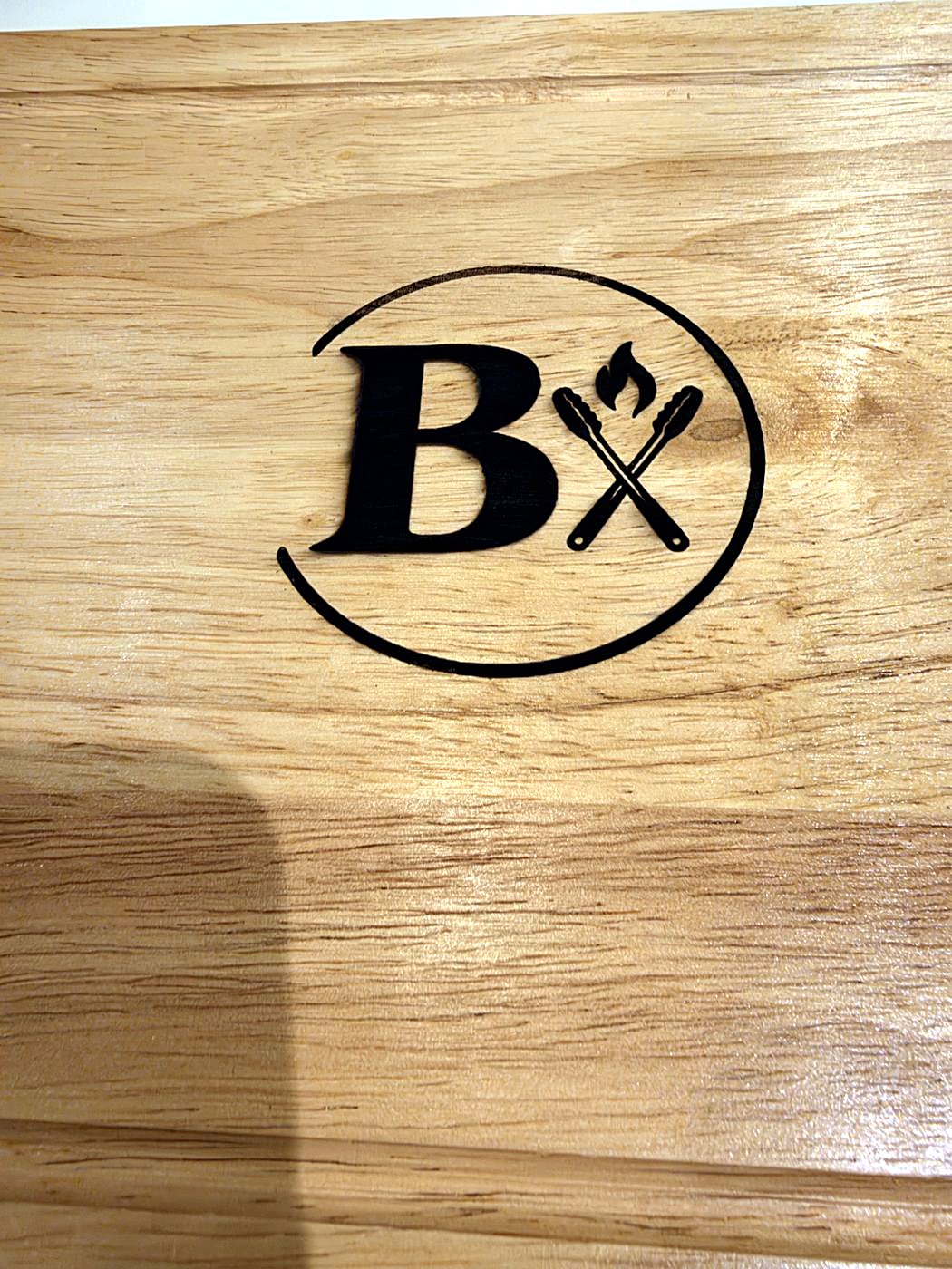 Close-up of the Braaikis logo engraved on hardwood